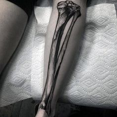 a woman's leg with a black and white tattoo on it