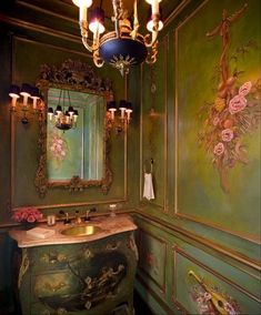 an ornate bathroom with green walls and gold fixtures, chandelier above the sink