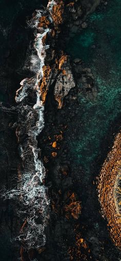 an aerial view of the ocean and rocks