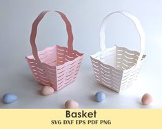 two paper baskets sitting next to each other on top of a white table with pink and blue eggs