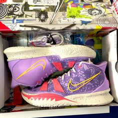 a pair of purple nike basketball shoes in a shoe box with colorful wrapping paper on top