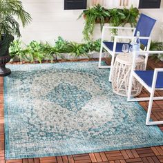 a blue and white rug sitting on top of a wooden floor next to a chair