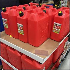 many red plastic jugs are stacked on top of each other in a store aisle