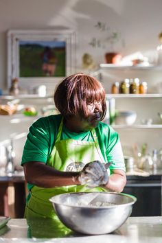 a woman in an apron is mixing something in a bowl