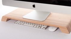 an apple computer sitting on top of a wooden keyboard and mouse pad with a white background