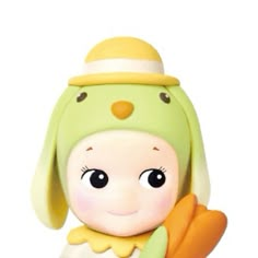 a small doll with a green hat and carrots in it's hands on a white background