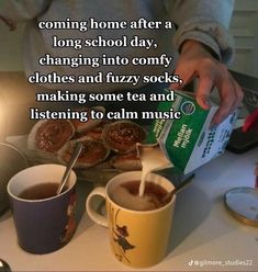 someone is pouring tea into their mugs on the table with cookies and other items