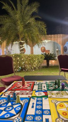 a game table with chairs and lights in the background