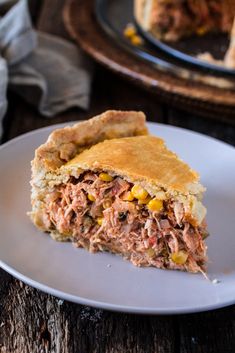 a piece of meat pie sitting on top of a white plate