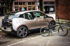 an electric car is parked next to a bicycle