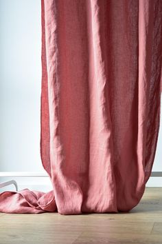 a pink curtain is open on the floor