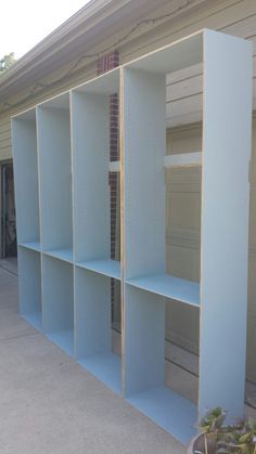 several blue shelving units in front of a house