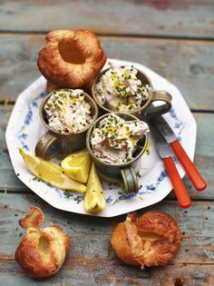 an assortment of pastries on a plate with spoons and utensils next to them