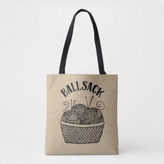 a tote bag that says ballsack with knitting needles and yarn in the basket