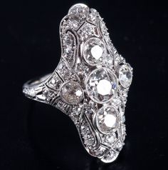 Vintage 1900s Platinum J SI1 Old European Diamond Filigree Cocktail Ring 2.19ctwMetal Information: .950 PlatinumTotal Weight: 5.56gBand Width: 1.65mmSize: 3.75Circa: 1900'sStone InformationMain StoneGem Type: DiamondShape: Old European (5.5mm)Color: JClarity/Quality: SI1Carat Weight: .65ctNumber of Stones: 1Accent StonesGem Type: DiamondShape: Oval (5mm x 4mm)Color: JClarity/Quality: SI1Carat Weight: .33ctNumber of Stones: 2Accent StonesGem Type: DiamondShape: Old European (3.7mm)Color: JClarity Alternative Wedding Dresses, Alternative Wedding, Cocktail Ring, Cocktail Rings, Beautiful Jewelry, Vintage Jewelry, Platinum, Wedding Dresses, Stone