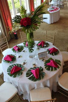 the table is set up with flowers and place settings for guests to sit down at