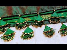 green and gold broochies are arranged on a white cloth