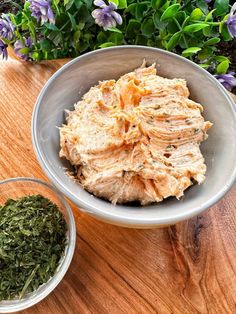 a bowl filled with food sitting on top of a wooden table next to two bowls