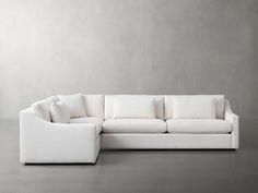 a white couch sitting on top of a gray floor