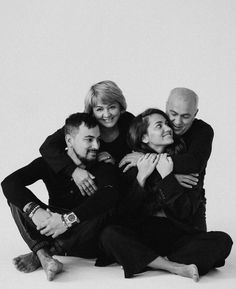 black and white photograph of four people hugging each other