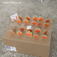 a cardboard box filled with lots of cut out pumpkins on top of a table