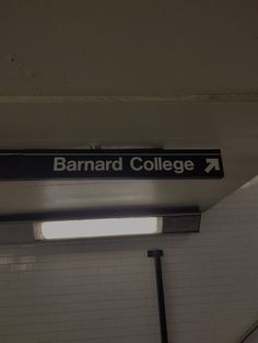 a black and white sign that says barnard college on it's side hanging from the ceiling