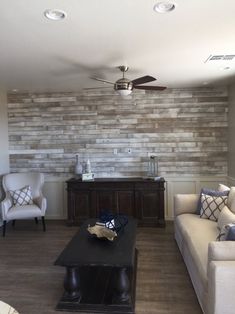 a living room filled with furniture and a flat screen tv mounted on a wall above a fireplace