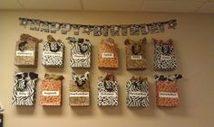 there are many bags hanging on the wall with zebra print and name tags attached to them