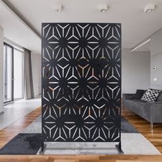 a room divider in the middle of a living room with wood floors and white walls