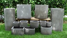 a group of cement pots sitting on top of a lush green field