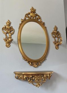 an ornate gold mirror, shelf and mirror on the wall with other antique items around it