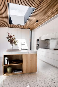 a kitchen with an open skylight above the sink and counter top, is shown