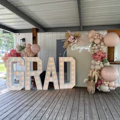 the letters grad are decorated with balloons and flowers