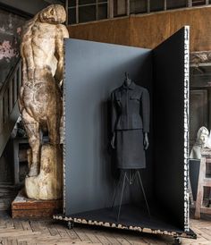 a mannequin is standing in front of an open door