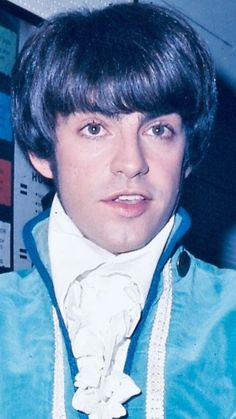 a young man wearing a blue jacket and white shirt