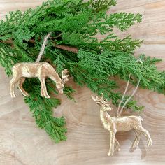 two deer ornaments sitting on top of a wooden table