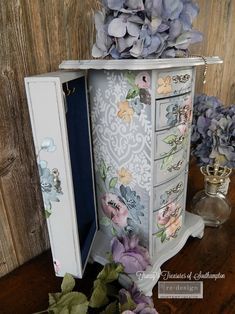 an old fashioned jewelry box with flowers on it