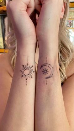 two women with matching tattoos on their arms, one has the sun and the other has the moon