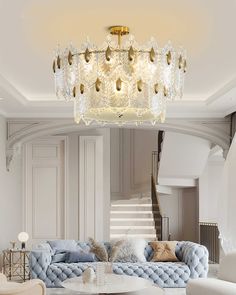 a living room filled with furniture and a chandelier hanging from the ceiling above it