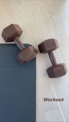 two chocolate dumbs sitting on top of a yoga mat with the words workout written below them