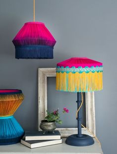 two colorful lamps are sitting on top of a dresser