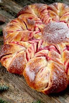 an apple croissant with powdered sugar on top sitting on a wooden table