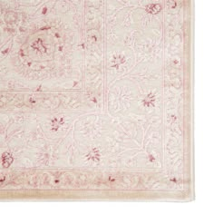 an antique rug with pink and white floral designs on the bottom, in front of a white background