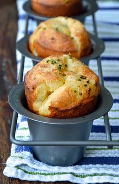 three muffins sitting in a metal pan on a blue and white table cloth