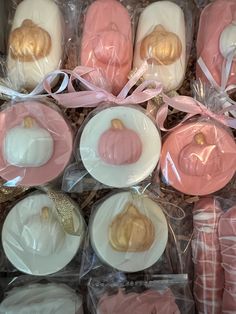 pink and white desserts in plastic wrappers with gold accents on them, sitting next to each other