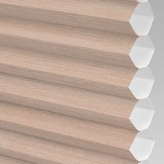 a close up view of the top of a wooden blind with pleated shades on it