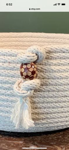 a close up of a white bag on a table with an object in the background