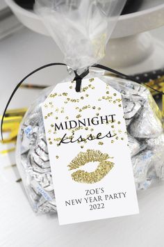 a white and gold new year's party bag with a name tag on it