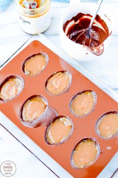 cupcakes with peanut butter and jelly in the middle on an orange tray, ready to be baked