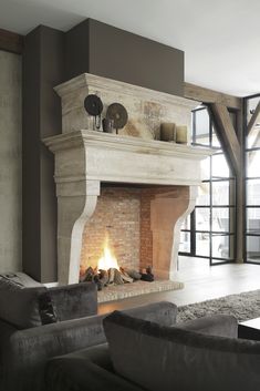 a living room filled with furniture and a fire place in the middle of it's fireplace